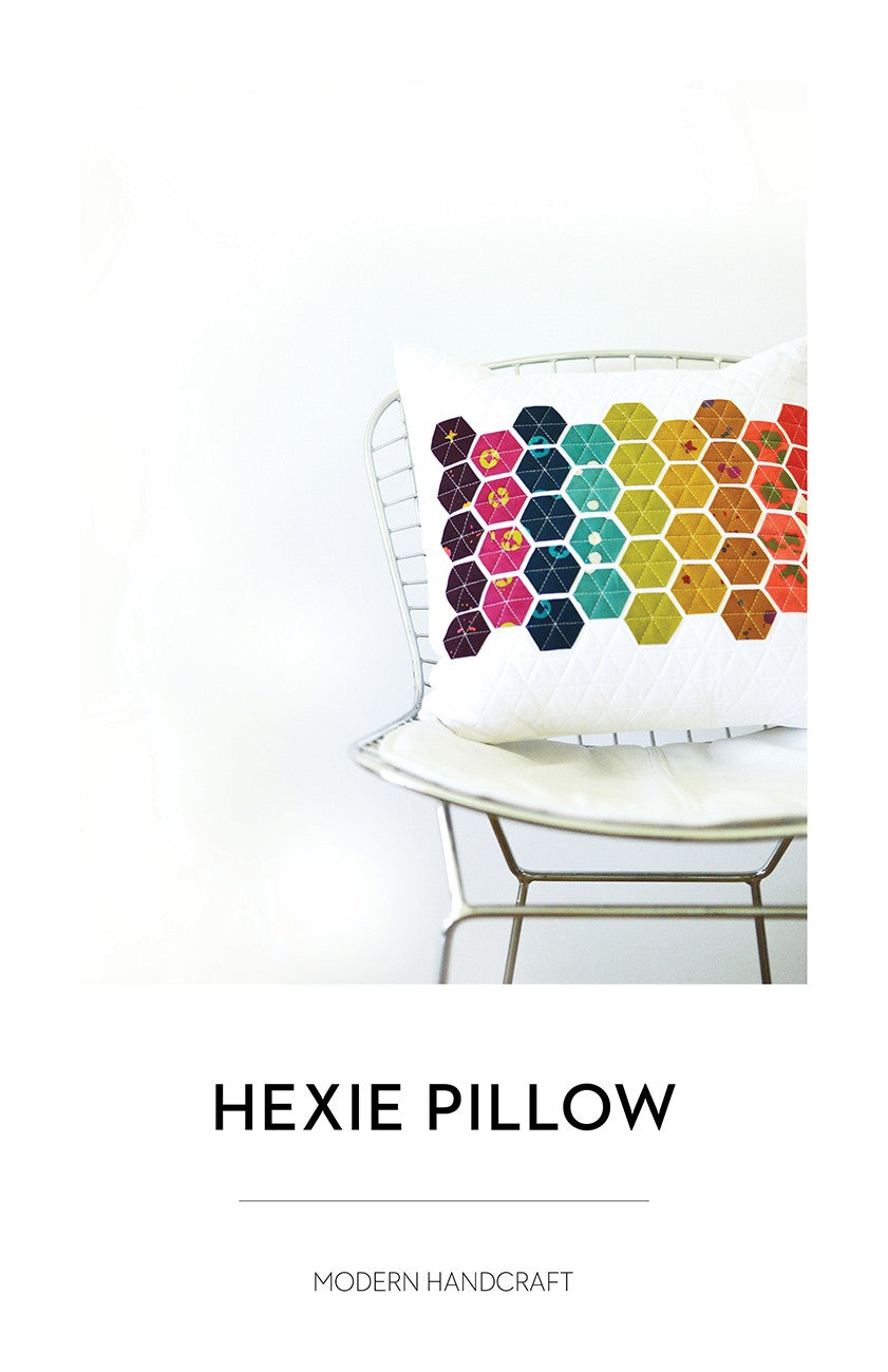 Hexie Pillow pattern by Modern Handcraft, white cushion with a rainbow hexagon panel